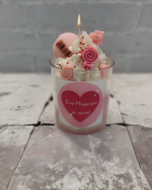 Handmade Pink Delight candle, decorated with vibrant pink hues, chocolate pieces, lollipops, and macarons. This sweet-looking candle adds a fun, colorful charm to any space and can be personalized with a custom message. Χειροποίητο κερί Pink Delight, διακοσμημένο με ροζ αποχρώσεις, κομμάτια σοκολάτας, γλειφιτζούρια και μακαρόν. Ένα κερί που συνδυάζει γλυκύτητα και χρώμα, ιδανικό για κάθε περίσταση, με δυνατότητα προσθήκης προσωπικού μηνύματος.