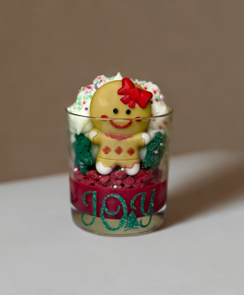 Χειροποίητο χριστουγεννιάτικο κερί JOY με gingerbread φιγούρα, κόκκινη βάση και festive διακόσμηση από τη Malenias.