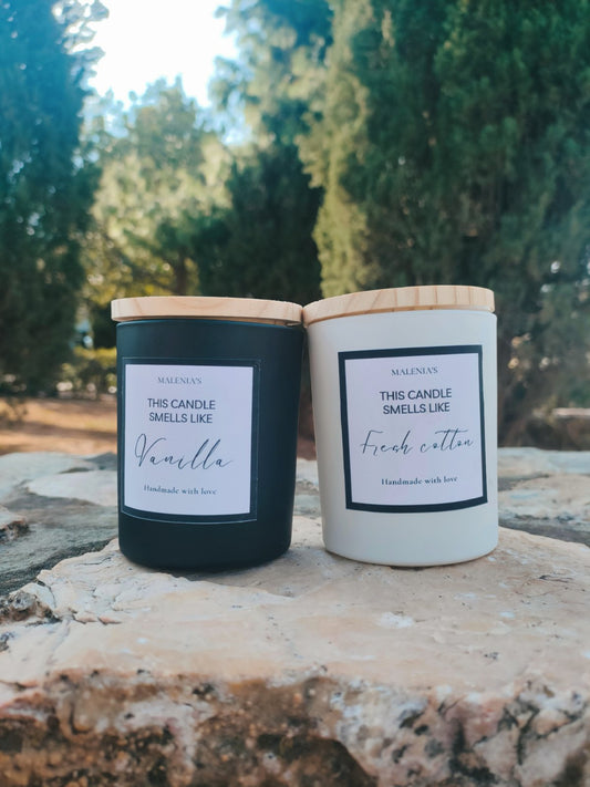 Handmade Classic Elegance soy candle in a black or white glass jar, available in fragrances like vanilla, coconut, white musk, ocean wave, fresh blossom, and sandalwood. Χειροποίητο κερί σόγιας Classic Elegance σε μαύρο ή λευκό γυάλινο δοχείο, διαθέσιμο σε αρώματα βανίλια, καρύδα, ανθός φρεσκάδας, και σανδαλόξυλο.